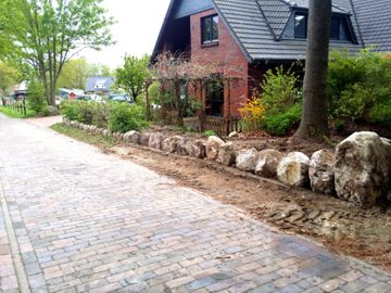 Setzen einer Natursteinmauer in Hambergen